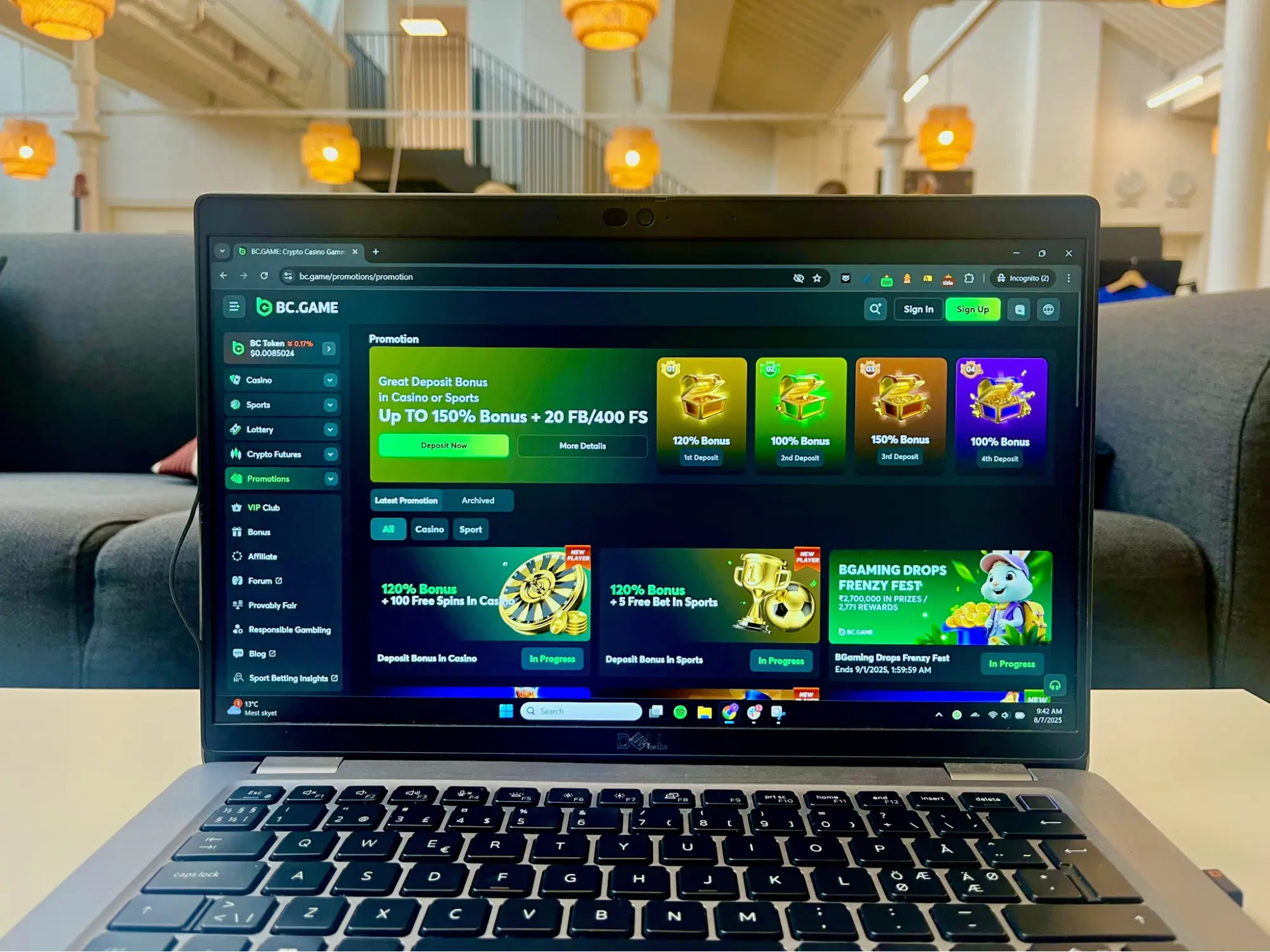 Open laptop on a table showing BC.Game online casino homepage with bonus offers and promotional banners.