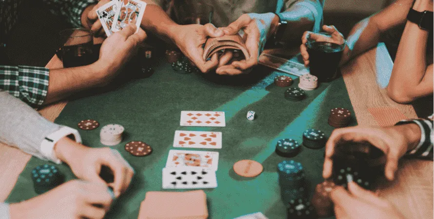 テーブルを囲んでポーカーで遊ぶ人々